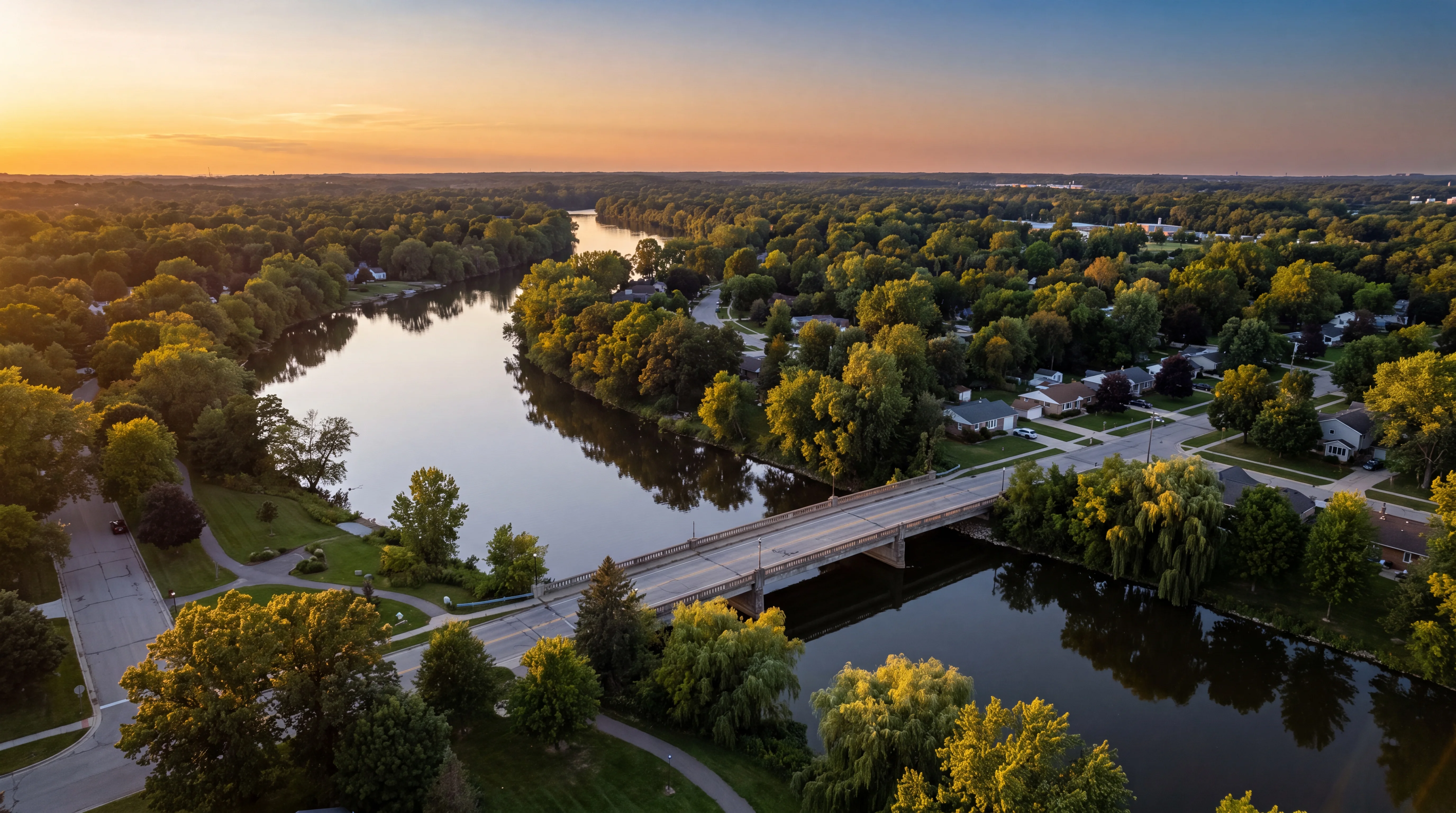The Grand River winding past a leafy West Michigan suburb